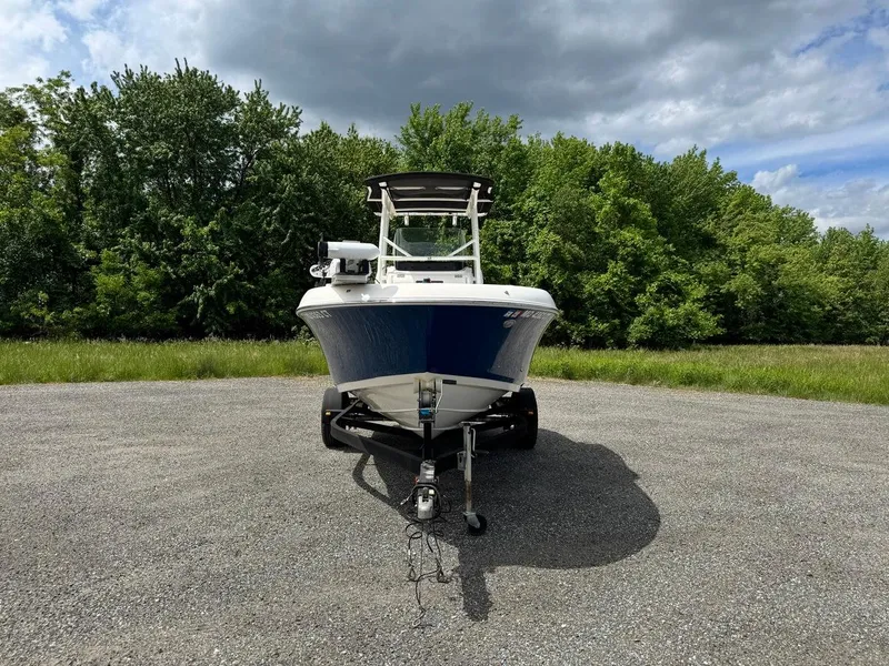 Slide: The Image of 2018 Wellcraft 182 Fisherman boat on trailer, parked on gravel with trees in background. - 7
