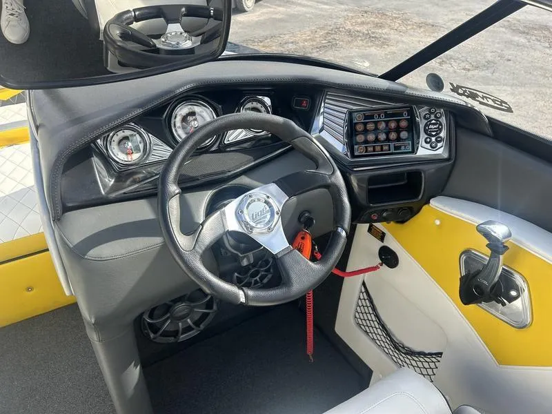 Slide: The Image of 2012 Tigé RZ2 boat dashboard with steering wheel, gauges, and control panel. - 5