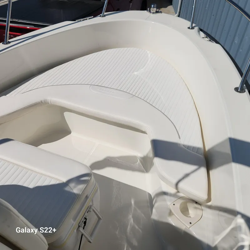 Slide: The Image of 2010 Boston Whaler 190 Outrage boat interior with white seating and railings. - 11