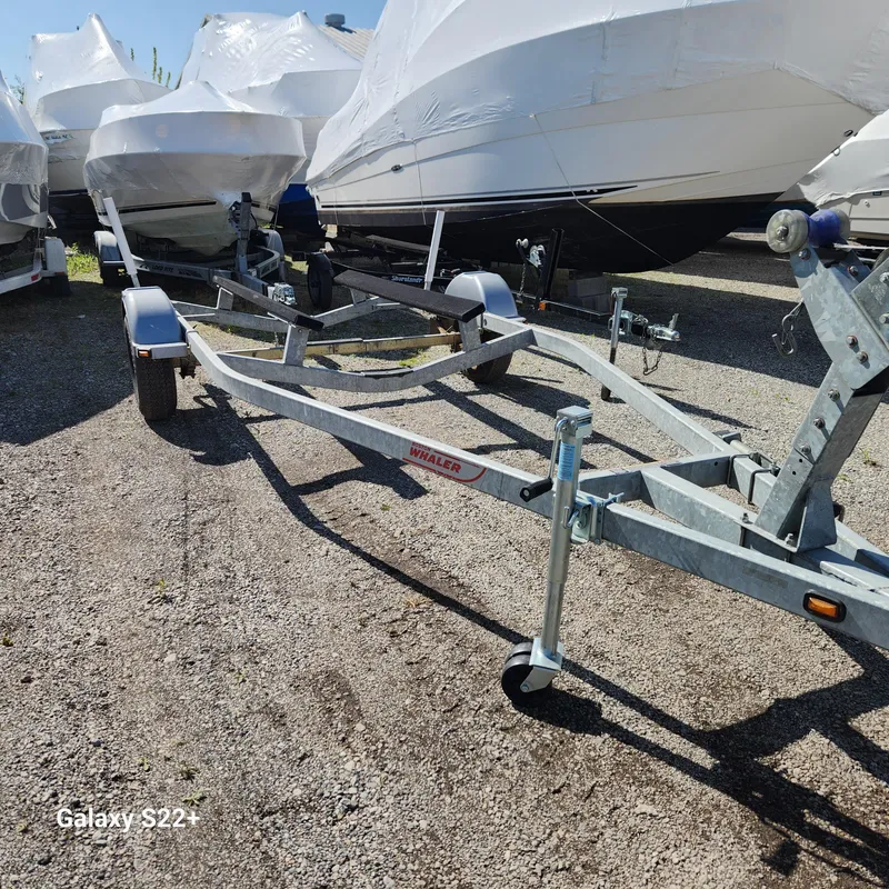 Slide: The Image of Boat trailer for 2010 Boston Whaler 190 Outrage, parked on gravel lot. - 17