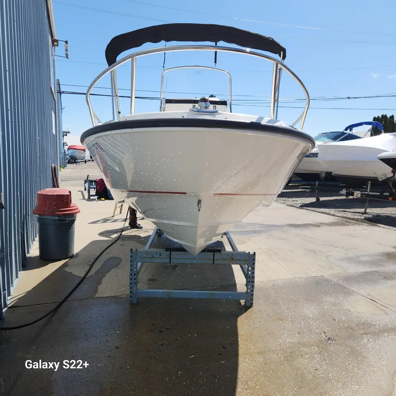 Slide: The Image of 2010 Boston Whaler 190 Outrage boat on a stand, sunny day, outdoor setting. - 2