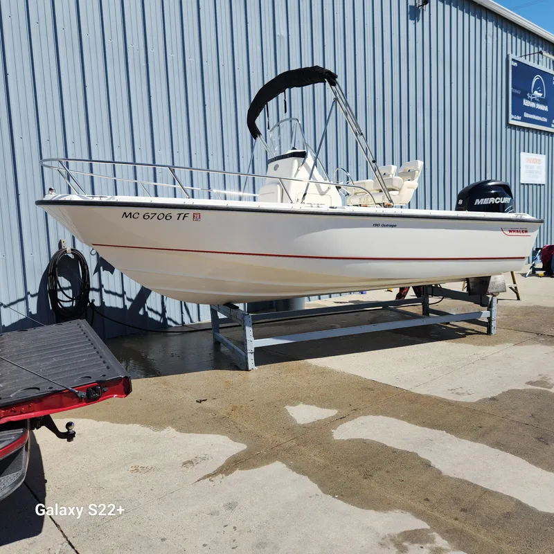 Slide: The Image of 2010 Boston Whaler 190 Outrage boat on trailer, parked outside marina. - 3
