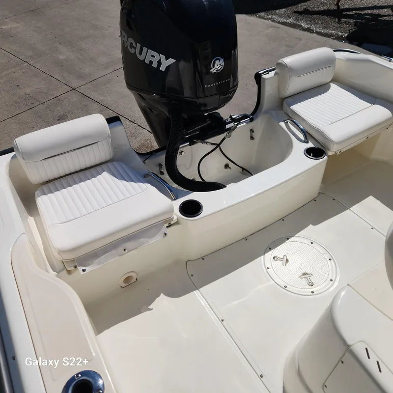 Slide: The Image of 2010 Boston Whaler 190 Outrage boat interior with Mercury engine and white seating. - 8