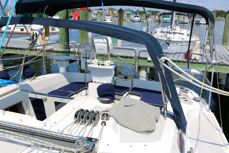 Slide: The Image of 2006 Catalina 350 sailboat cockpit with marina view, featuring seating and steering wheel. - 12
