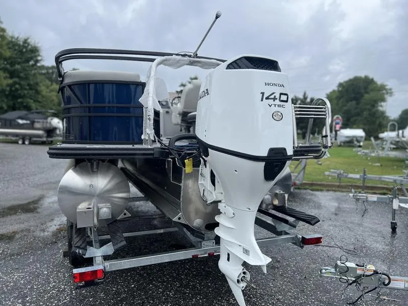 Slide: The Image of 2024 Sylvan Mirage X1 pontoon boat with Honda 140 VTEC engine on trailer. - 2
