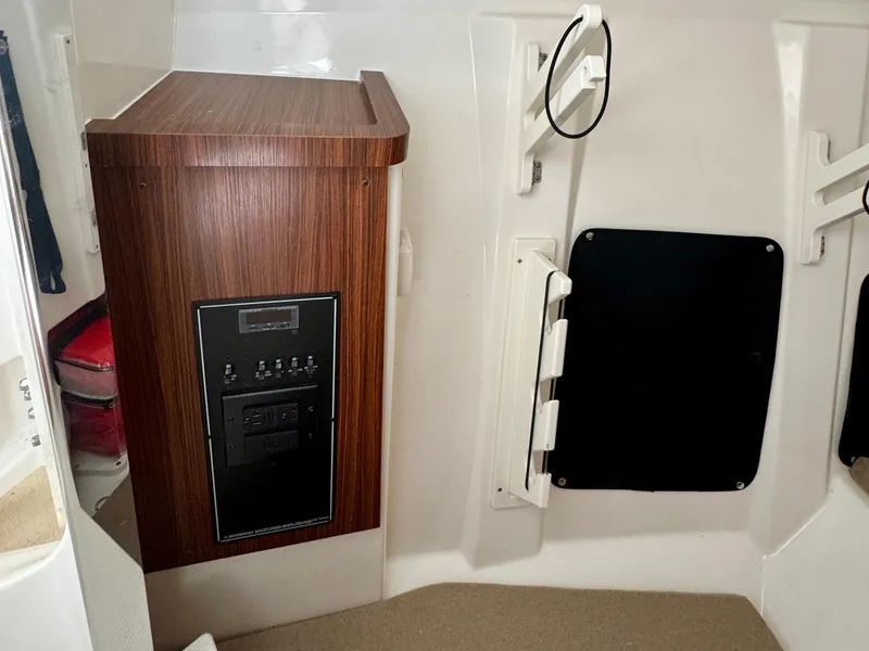 Slide: The Image of 2024 Pursuit DC 295 Dual Console interior with wood paneling and control panel. - 15