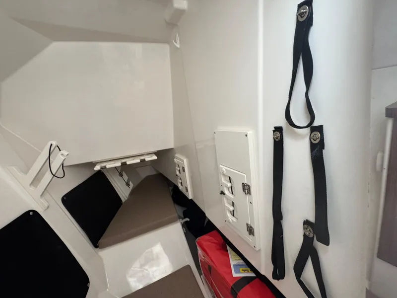 Slide: The Image of 2024 Pursuit DC 295 Dual Console interior cabin with seating and storage straps. - 17