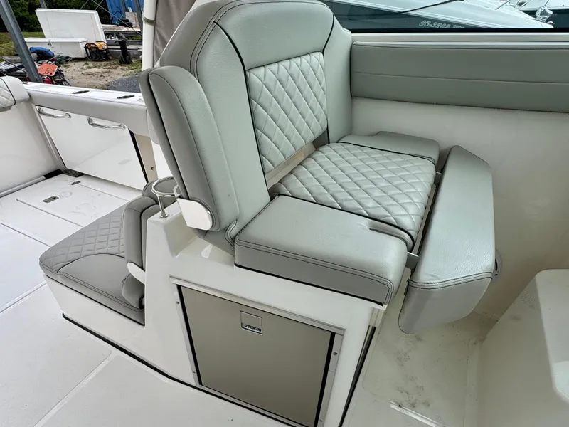 Slide: The Image of 2024 Pursuit DC 295 Dual Console boat interior with cushioned seating and storage. - 21