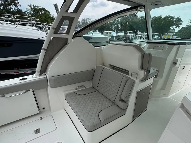 Slide: The Image of 2024 Pursuit DC 295 Dual Console interior with cushioned seating and modern design. - 24