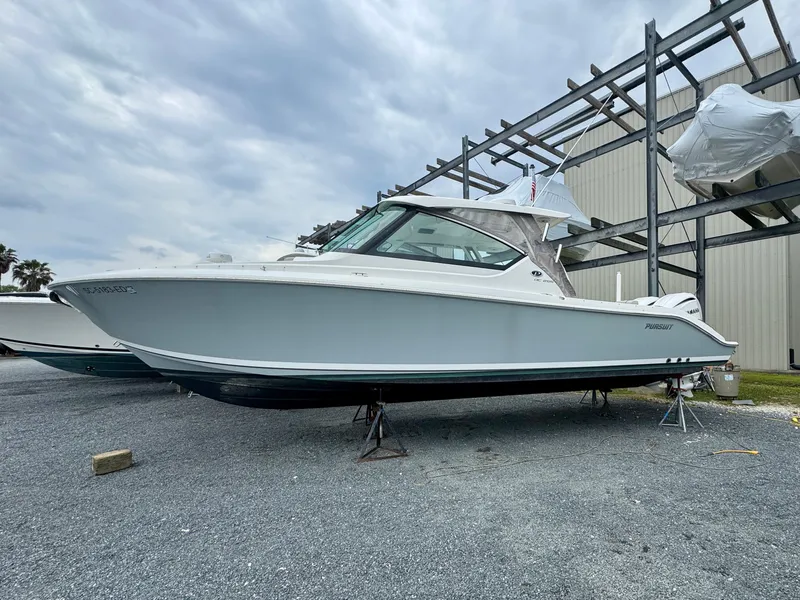 Slide: The Image of 2024 Pursuit DC 295 Dual Console boat on display outdoors. - 29