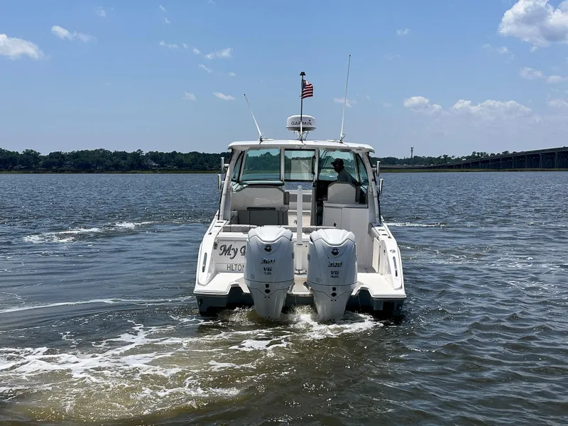 Slide: The Image of 2024 Pursuit DC 295 Dual Console boat cruising on a sunny day. - 6