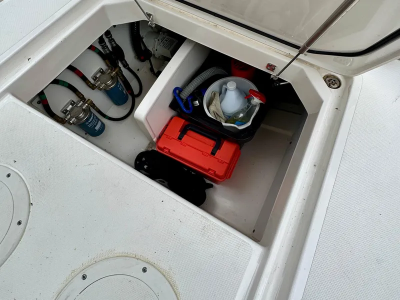 Slide: The Image of Storage compartment of 2024 Pursuit DC 295 Dual Console boat with equipment and supplies. - 7