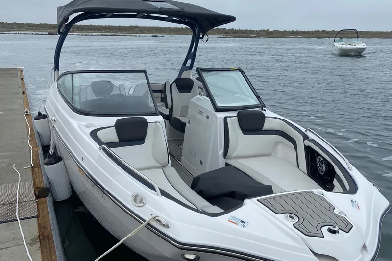 Slide: The Image of 2020 Yamaha Boats AR242SE docked on calm water, featuring sleek design and spacious seating. - 7