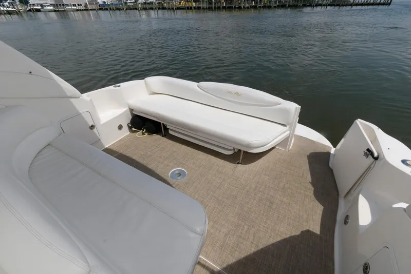 Slide: The Image of 2000 Sea Ray 340 Sundancer boat deck with white seating, docked on calm water. - 10