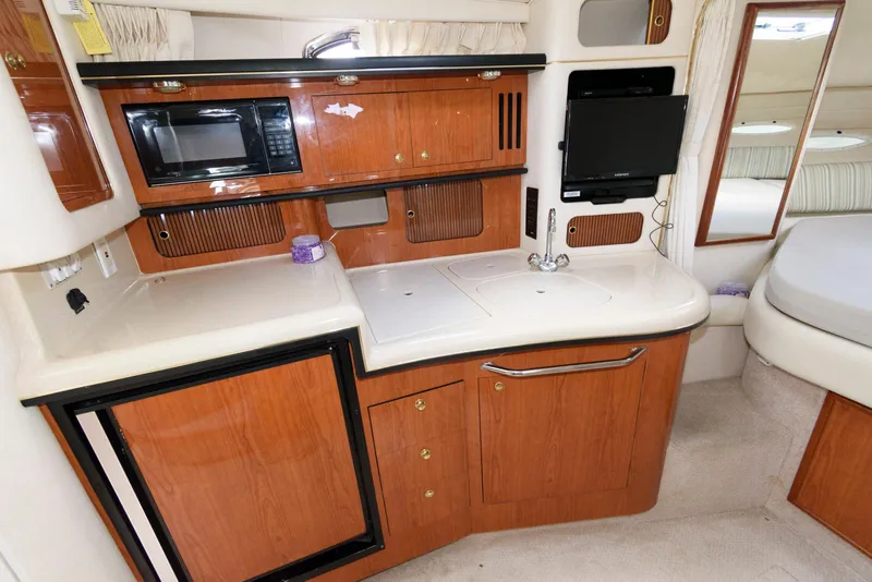 Slide: The Image of Interior of 2000 Sea Ray 340 Sundancer yacht with kitchenette and modern amenities. - 13