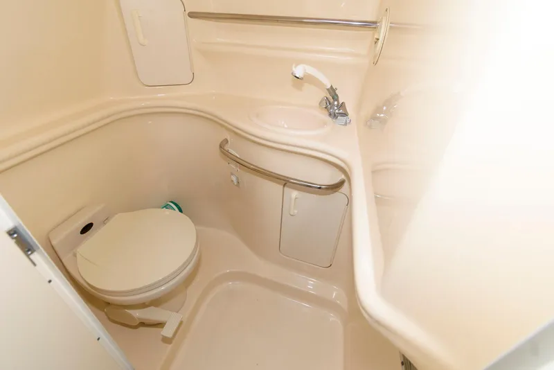 Slide: The Image of 2000 Sea Ray 340 Sundancer bathroom with compact toilet and sink. - 16