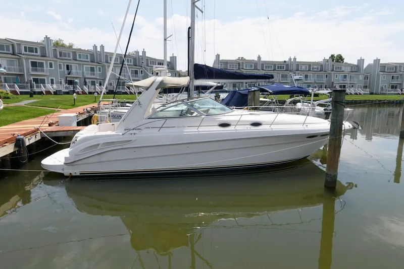Slide: The Image of 2000 Sea Ray 340 Sundancer docked in a marina with waterfront townhouses in the background. - 2