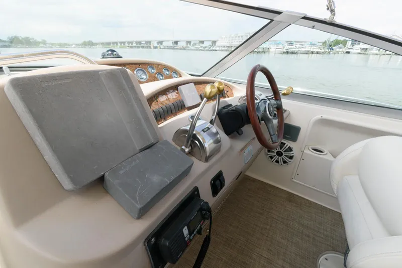 Slide: The Image of Helm of 2000 Sea Ray 340 Sundancer with steering wheel and control panel, overlooking water. - 8