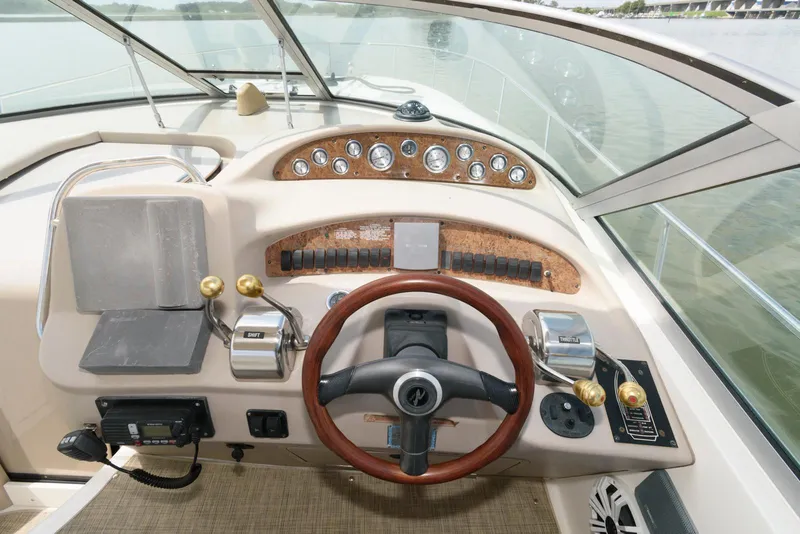 Slide: The Image of Cockpit of 2000 Sea Ray 340 Sundancer with wood-accented steering wheel and control panel. - 9
