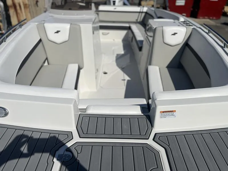 Slide: The Image of 2025 Starcraft SVX 231 OB boat interior with gray and white seating. - 2
