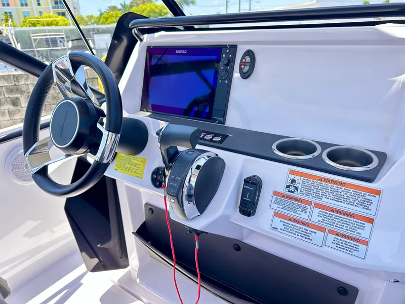 Slide: The Image of 2022 Axopar 22 T-Top boat dashboard with steering wheel and navigation display. - 18
