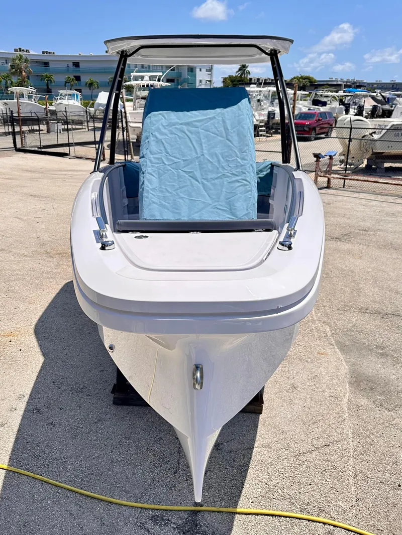 Slide: The Image of 2022 Axopar 22 T-Top boat, front view, docked under clear blue sky. - 2