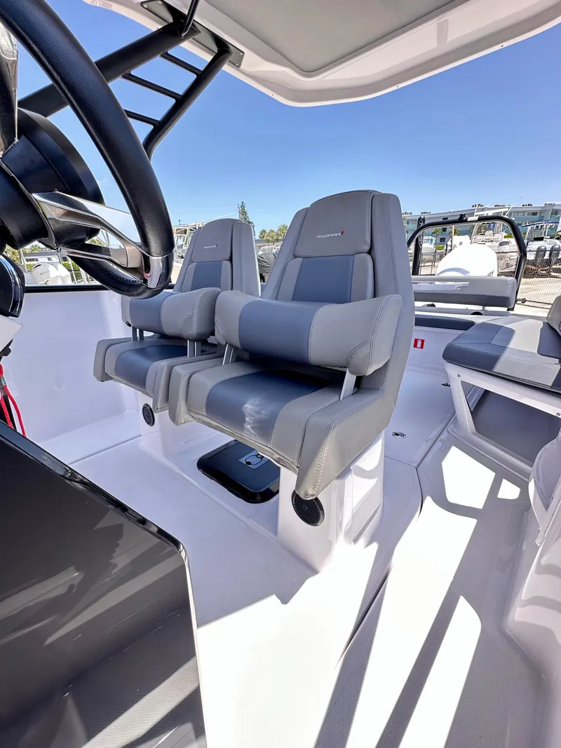 Slide: The Image of 2022 Axopar 22 T-Top boat interior with modern seating and steering wheel. - 21