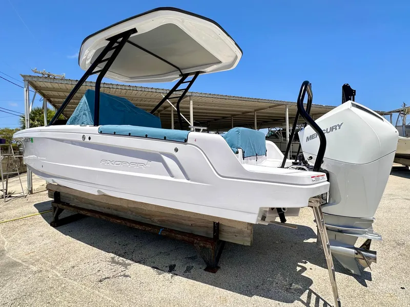 Slide: The Image of 2022 Axopar 22 T-Top boat with Mercury engine, displayed outdoors. - 5