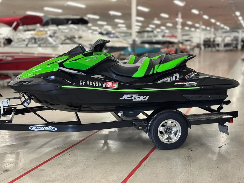 Slide: The Image of 2023 Kawasaki Jetski Ultra 310LX-S in showroom, green and black design on trailer. - 2