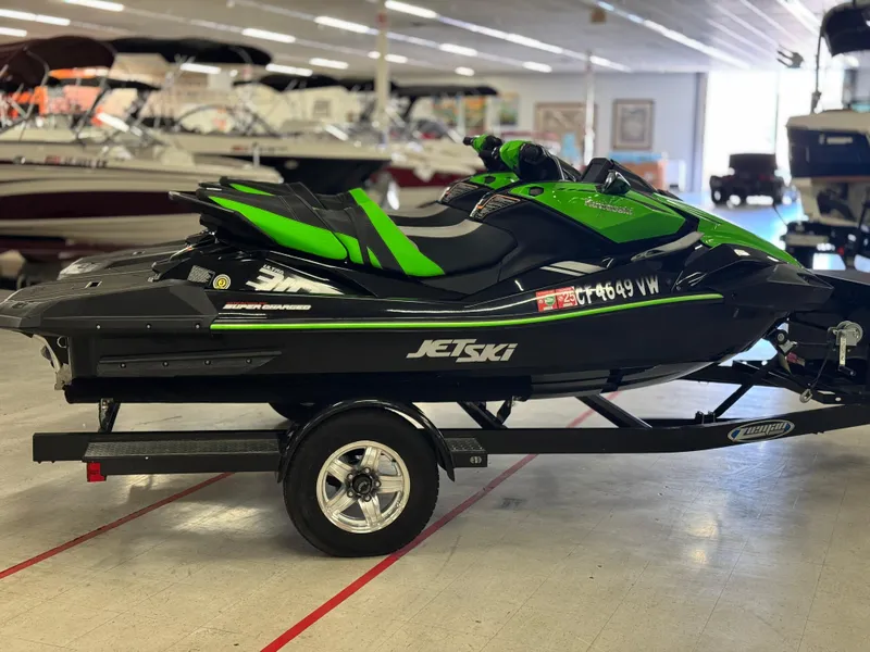 Slide: The Image of 2023 Kawasaki Jetski Ultra 310LX-S on trailer in showroom, green and black design. - 8
