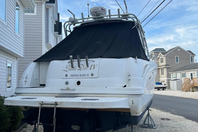 Slide: The Image of 2000 Sea Ray 290 Amberjack boat docked near coastal homes, rear view. - 11