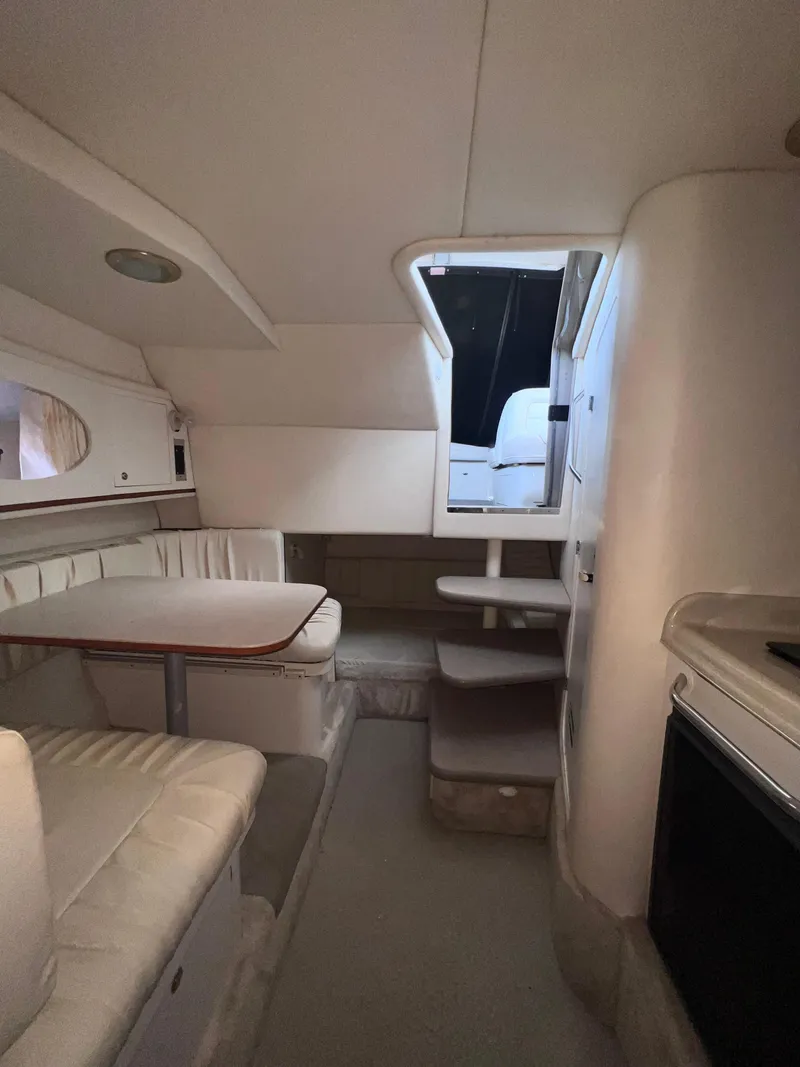 Slide: The Image of 2000 Sea Ray 290 Amberjack cabin interior with seating and stairs. - 12