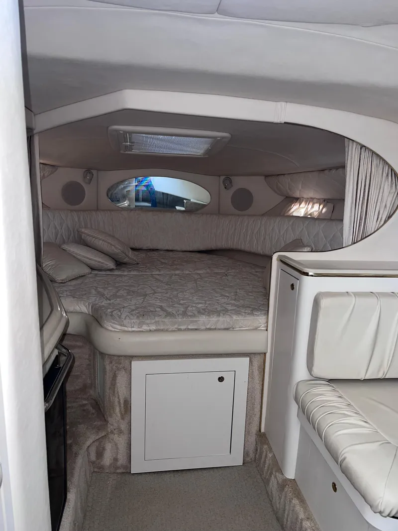 Slide: The Image of 2000 Sea Ray 290 Amberjack cabin interior with bed and seating area. - 15