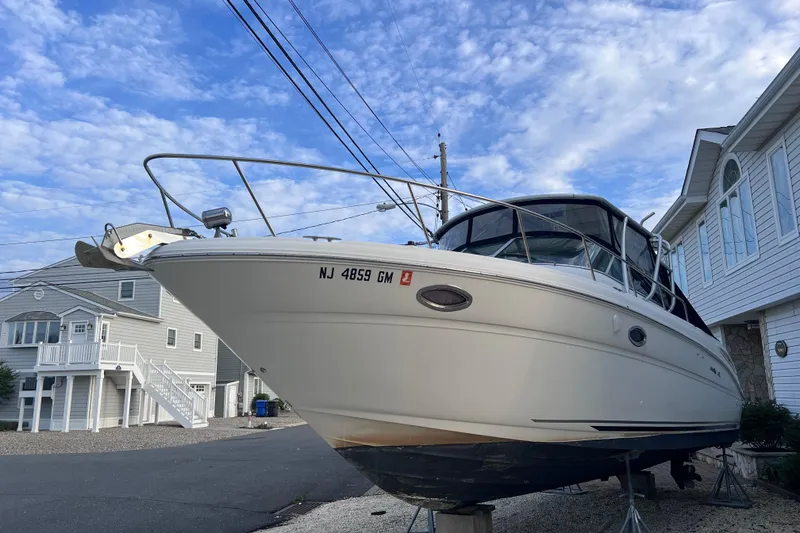 Slide: The Image of 2000 Sea Ray 290 Amberjack boat on dry dock, residential street background. - 2