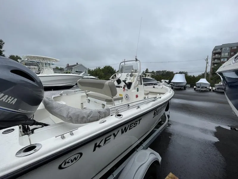 Slide: The Image of 2023 Key West 1720 CC boat in a marina, featuring Yamaha engine, overcast sky. - 2