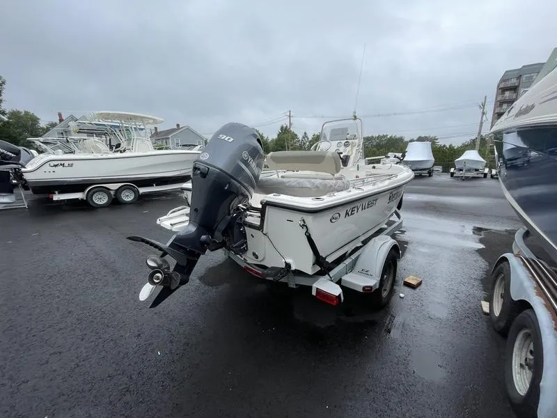 Slide: The Image of 2023 Key West 1720 CC boat on trailer, parked outdoors on wet pavement. - 3
