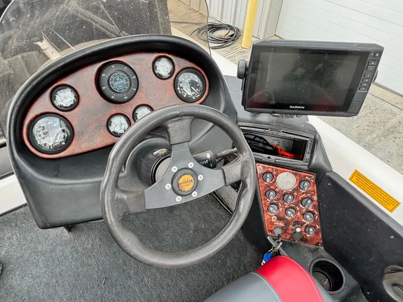 Slide: The Image of 1999 Triton TR19 boat dashboard with steering wheel and Garmin navigation system. - 10