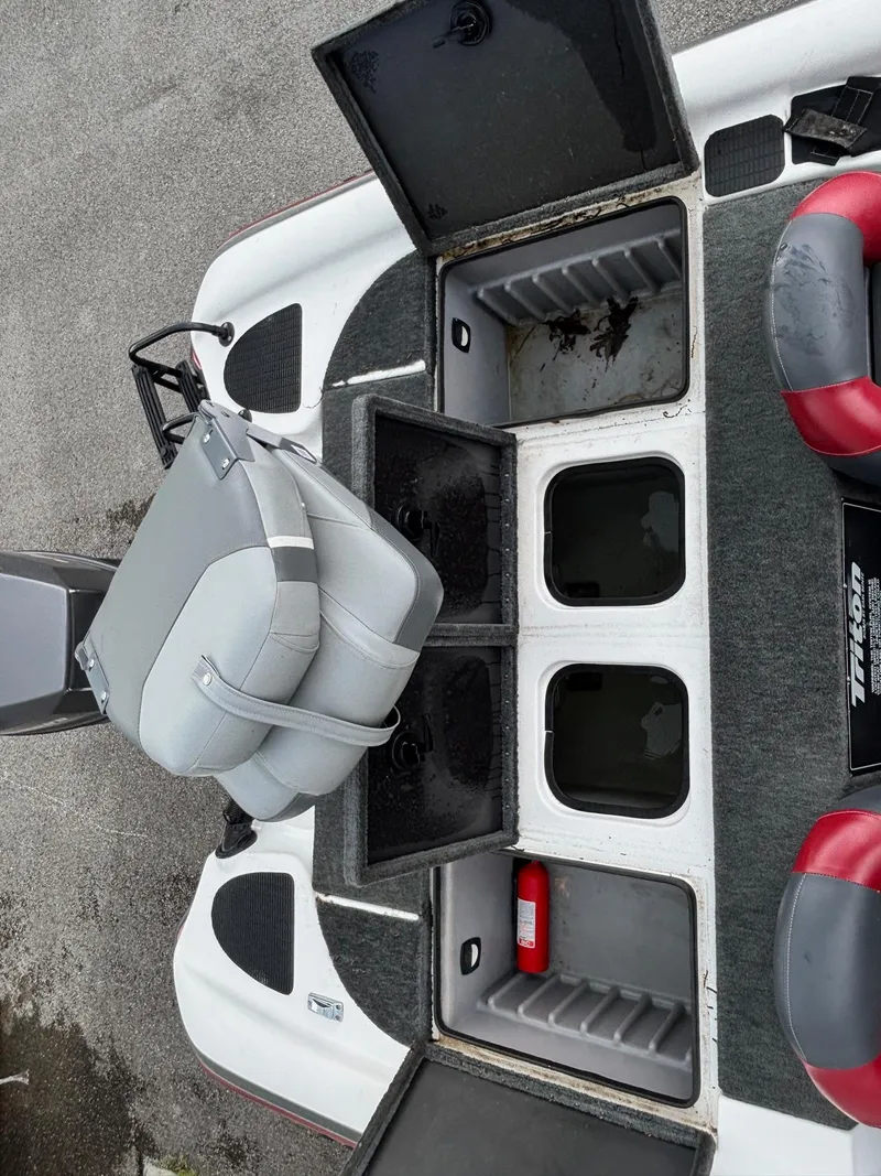 Slide: The Image of 1999 Triton TR19 boat interior with open storage compartments and seating. - 11