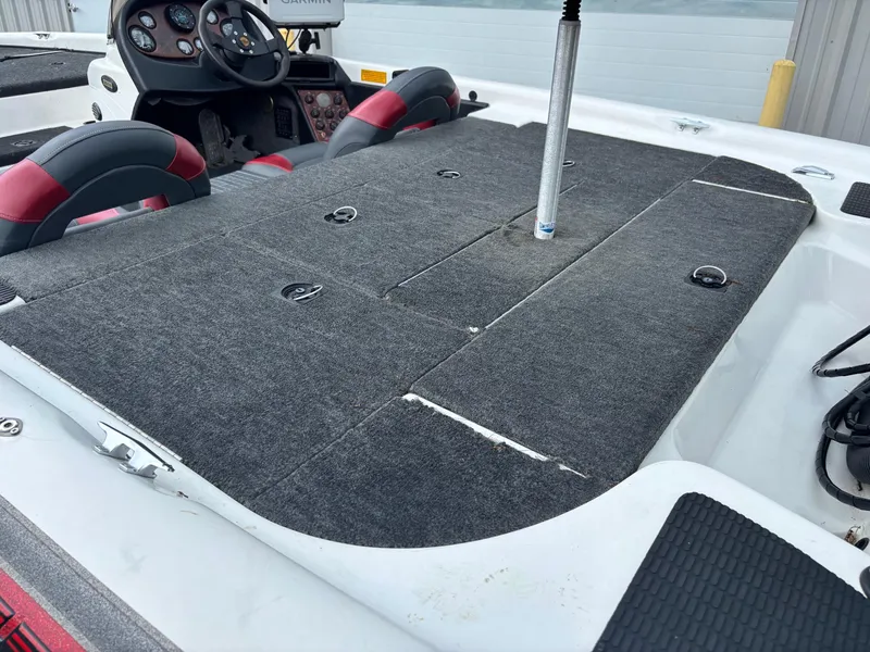 Slide: The Image of 1999 Triton TR19 boat interior with gray carpeted deck and steering console. - 12