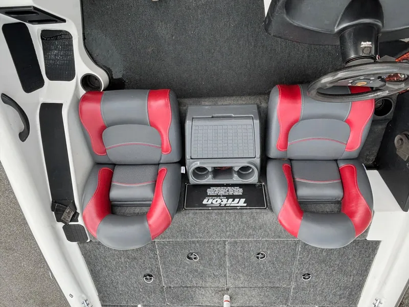 Slide: The Image of 1999 Triton TR19 boat interior with red and gray seats, steering wheel, and storage compartments. - 9