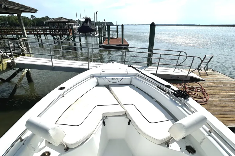 Slide: The Image of 2017 Sea Hunt Ultra 235 SE boat docked by a scenic waterfront. - 12
