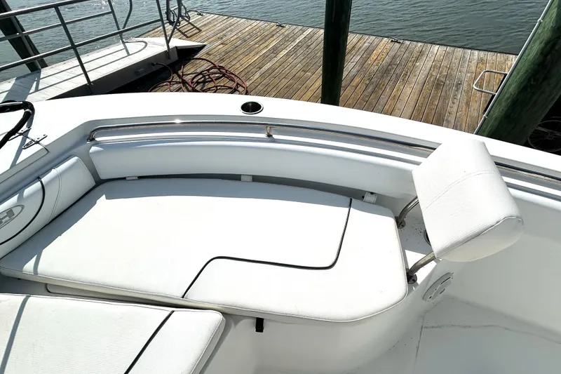 Slide: The Image of 2017 Sea Hunt Ultra 235 SE boat with white seating and dock view. - 14