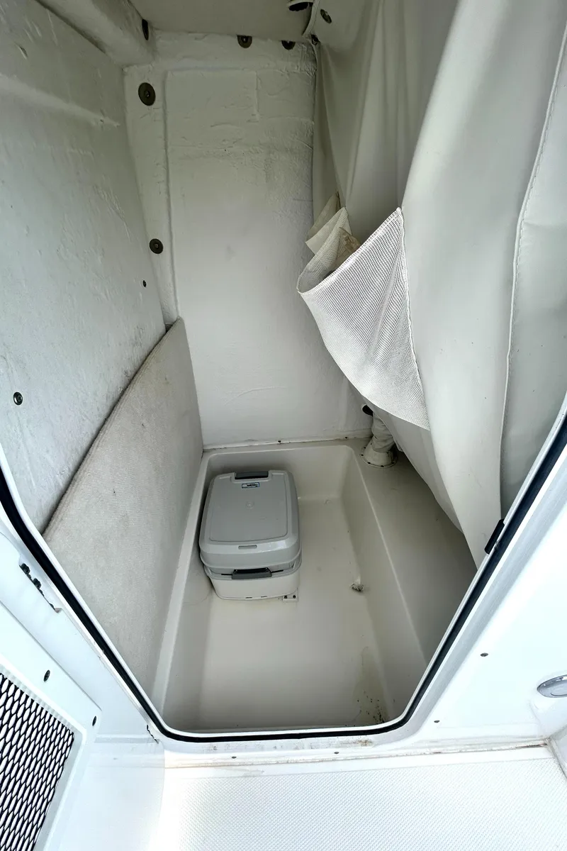 Slide: The Image of Interior of 2017 Sea Hunt Ultra 235 SE boat with compact portable toilet. - 16