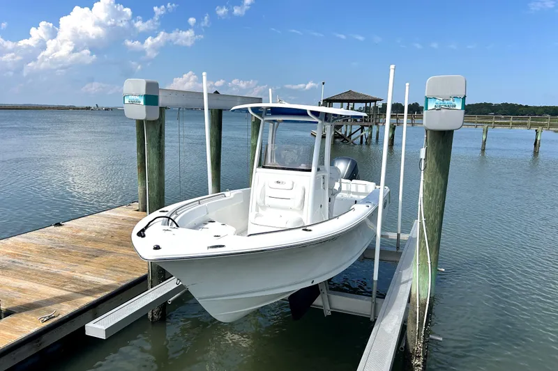Slide: The Image of 2017 Sea Hunt Ultra 235 SE boat docked on a lift by the water. - 3