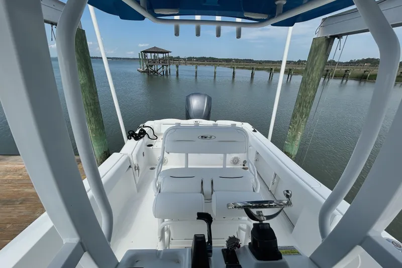 Slide: The Image of 2017 Sea Hunt Ultra 235 SE boat docked, showcasing interior seating and controls. - 6