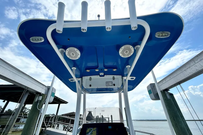 Slide: The Image of 2017 Sea Hunt Ultra 235 SE boat with blue T-top and rod holders. - 9