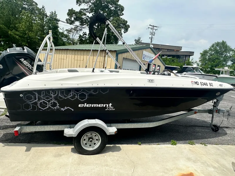 Slide: The Image of 2015 Bayliner Element E180 boat on trailer, parked outdoors. - 1