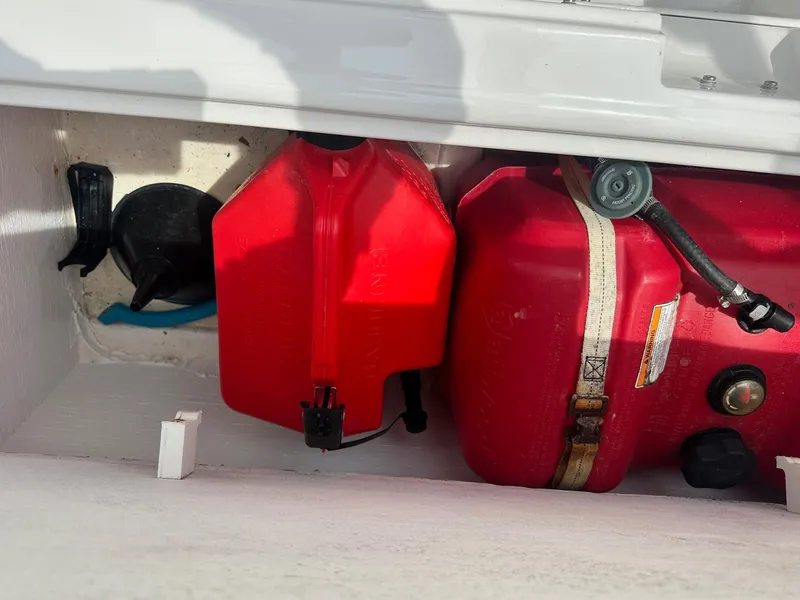 Slide: The Image of Storage compartment with red fuel tanks in a 2015 Bayliner Element E180 boat. - 13