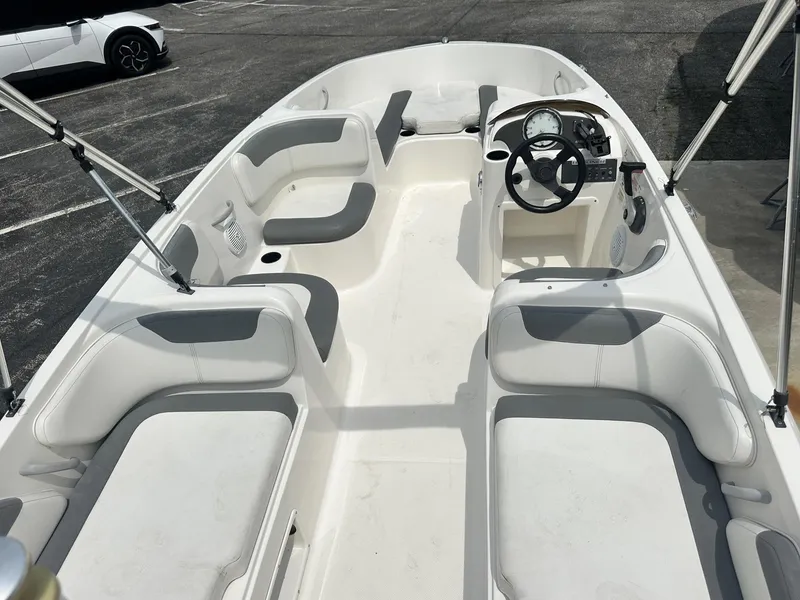 Slide: The Image of 2015 Bayliner Element E180 boat interior with white seating and steering wheel. - 15