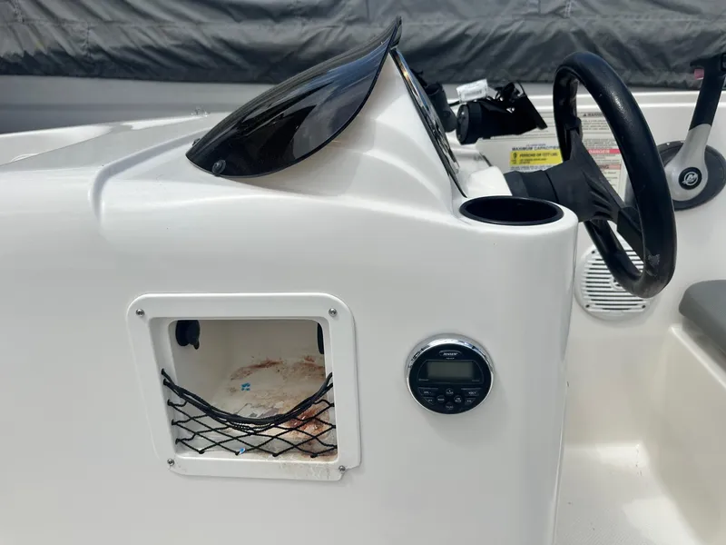 Slide: The Image of 2015 Bayliner Element 180 XL dashboard with steering wheel and storage compartment. - 21